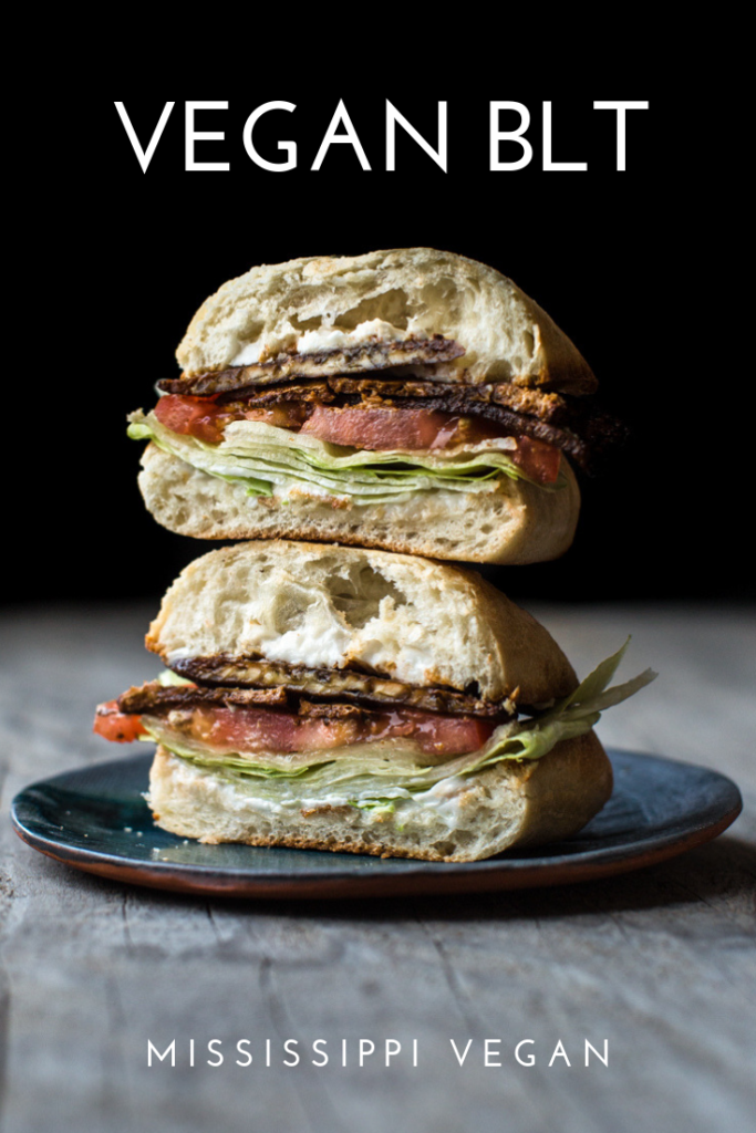 Vegan BLT cut in half and stack on top of each other on a plate
