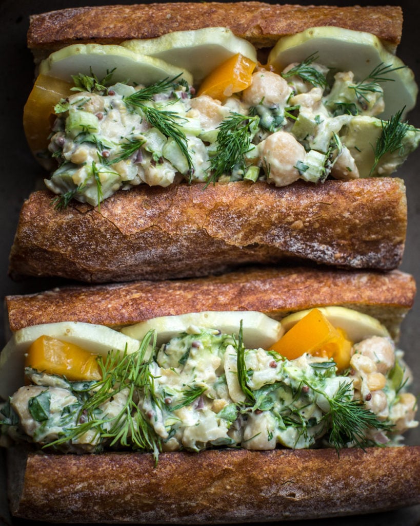 Two chickpea avocado sandwiches stacked on top of each one another