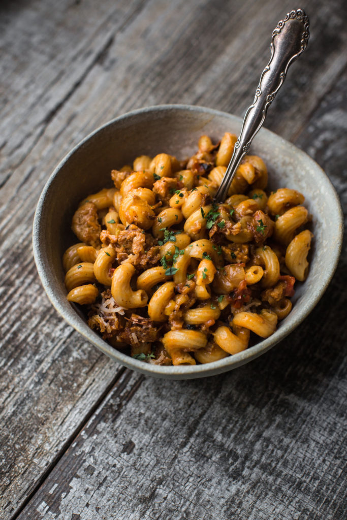 Vegan hamburger helper in a grey bowl with a utensil sticking out