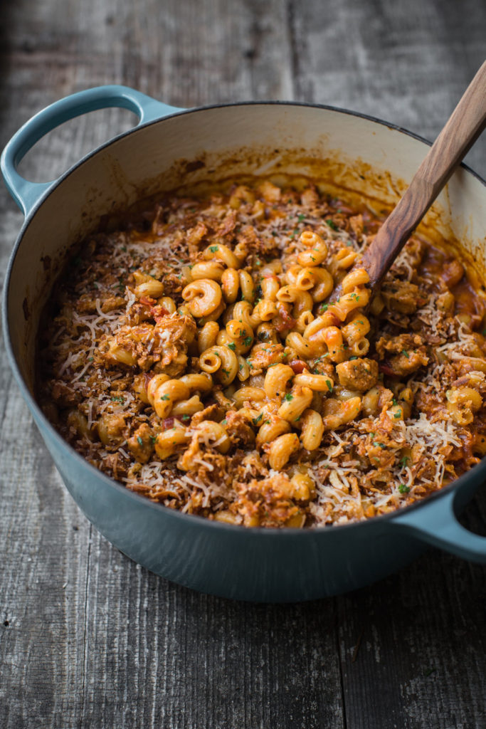 Large pot of vegan hamburger helper with wooden spoon sticking out