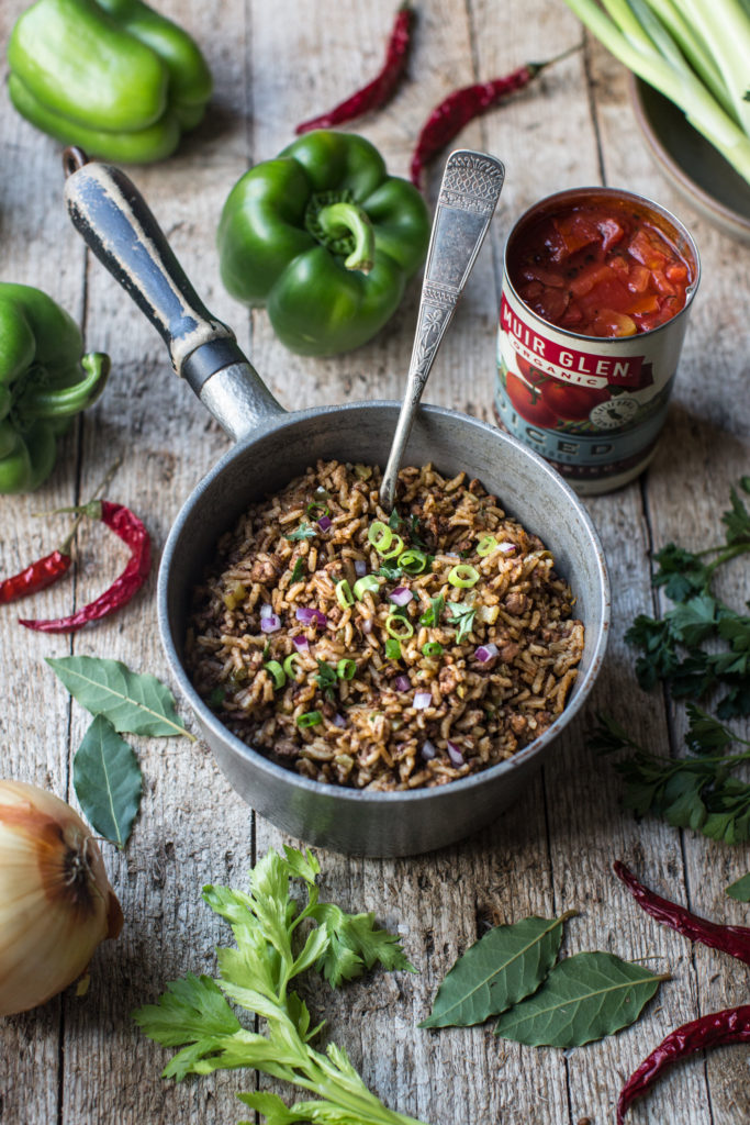 Pot of dirty rice surrounded by key ingredients