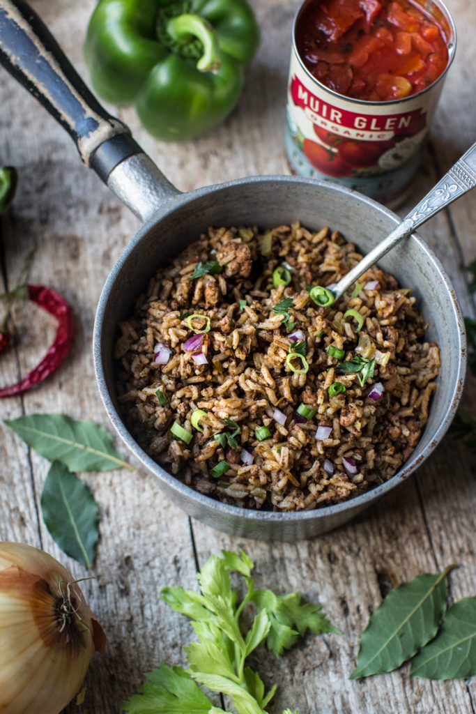 Dirty Rice in a pot surrounded by key ingredients