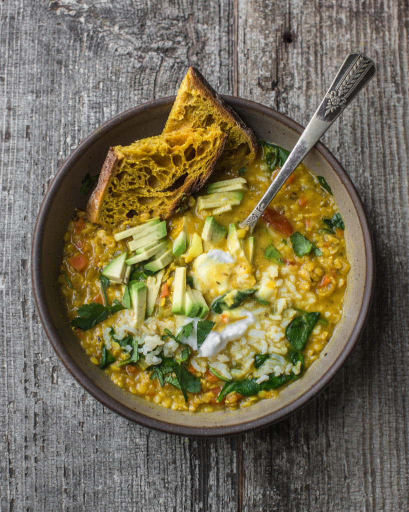 overhead shot of vegan dahl in a bowl on a wooden table