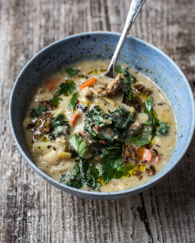 Bowl of Zuppa Toscana with a spoonful of ingredients at the top
