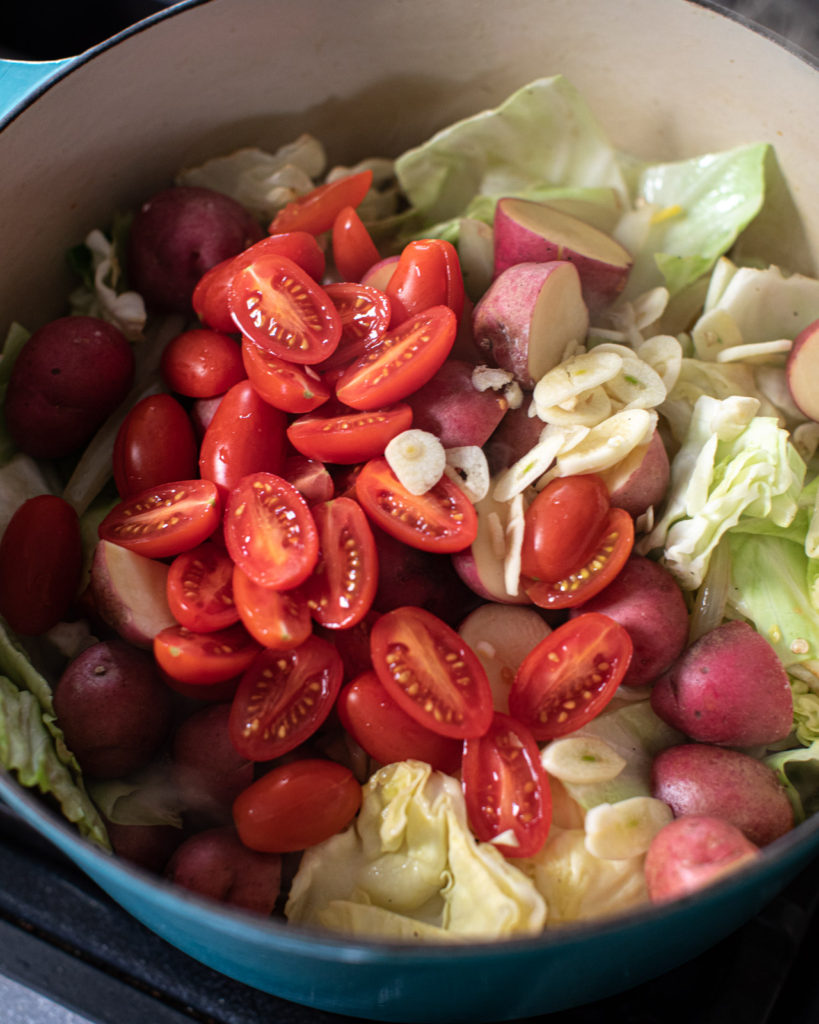 Cherry tomatoes and chopped vegetables in a pot