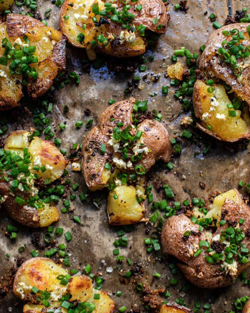 Crispy crawtators on a baking sheet with freshly chopped chives