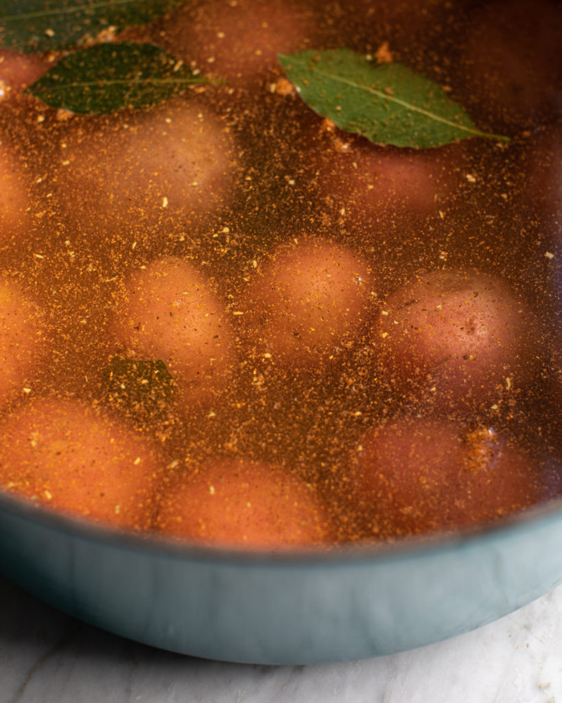 Red potatoes submerged in a broth