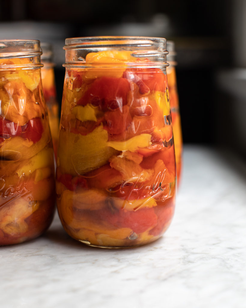 Glass jars filled with pickled roasted peppers