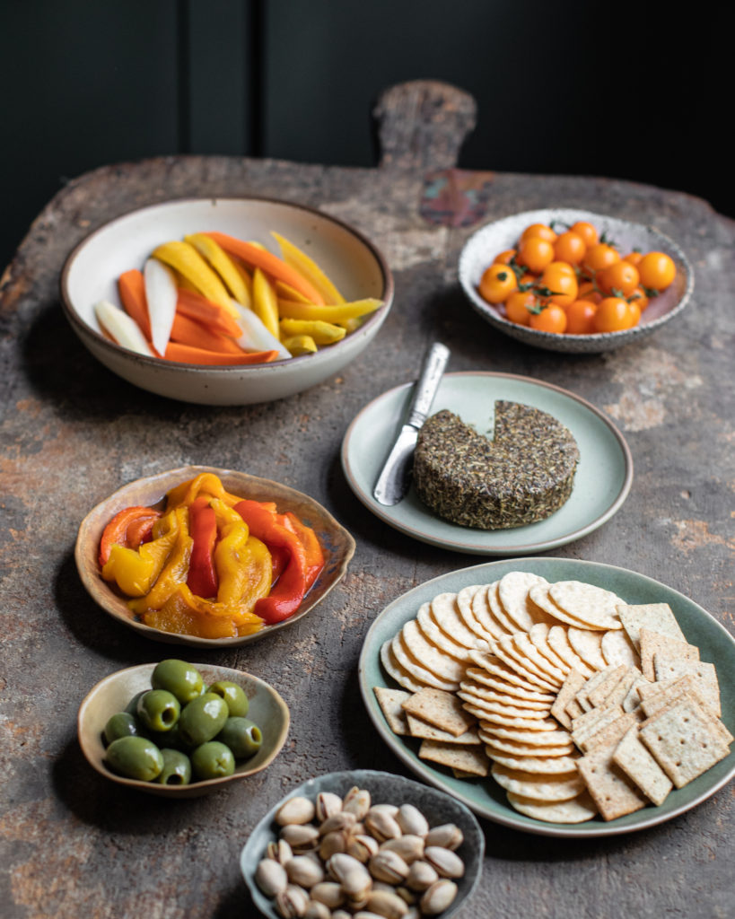 Table spread with different sides including pickled roasted peppers