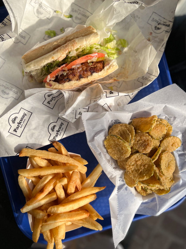 Vegan poboy with sides of fries and fried pickles