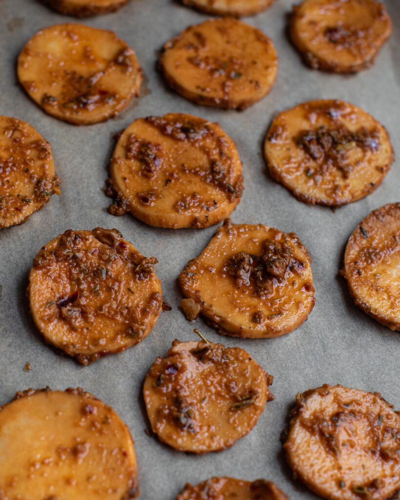 trumpet mushrooms with herbs and spices on a baking sheet