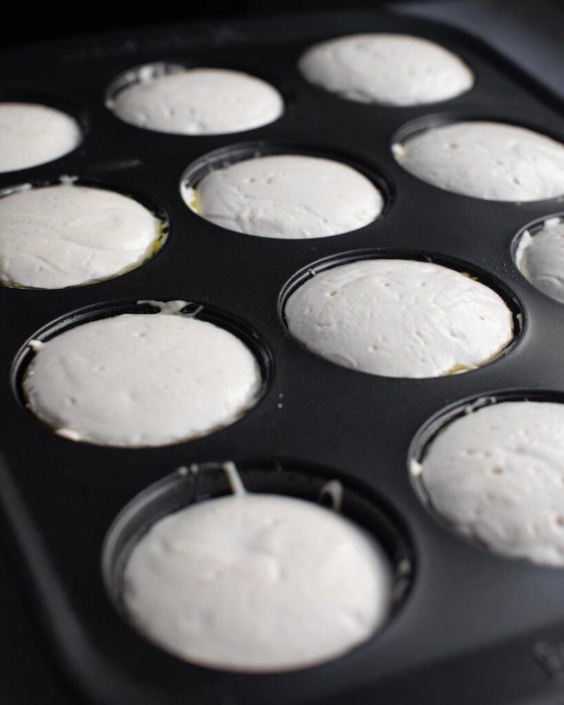 Dinner roll batter in muffin pan after batter has risen