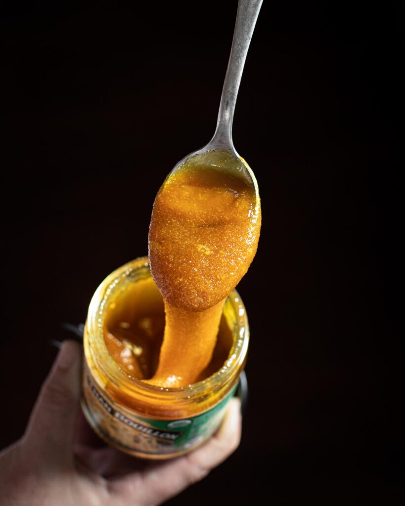 Heaping spoonful of vegetable bouillon dripping into the jar