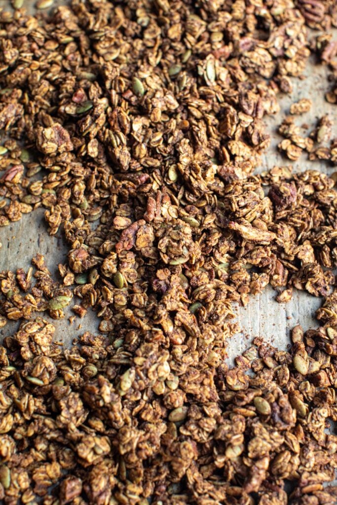 Cooked granola on a parchment paper lined baking sheet