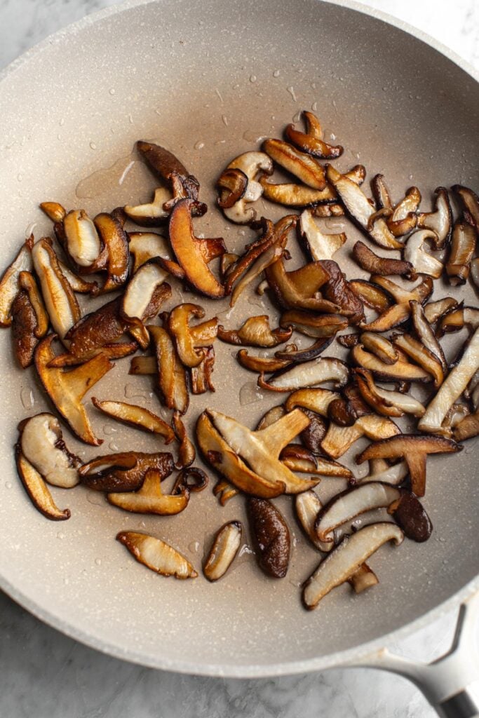 Shiitake mushrooms cooking in a pan