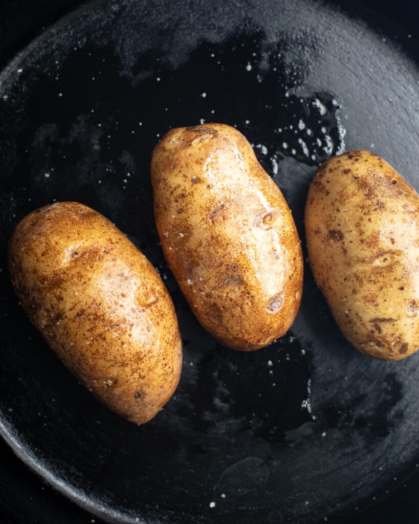potatoes coated with olive oil and salt in a large skillet