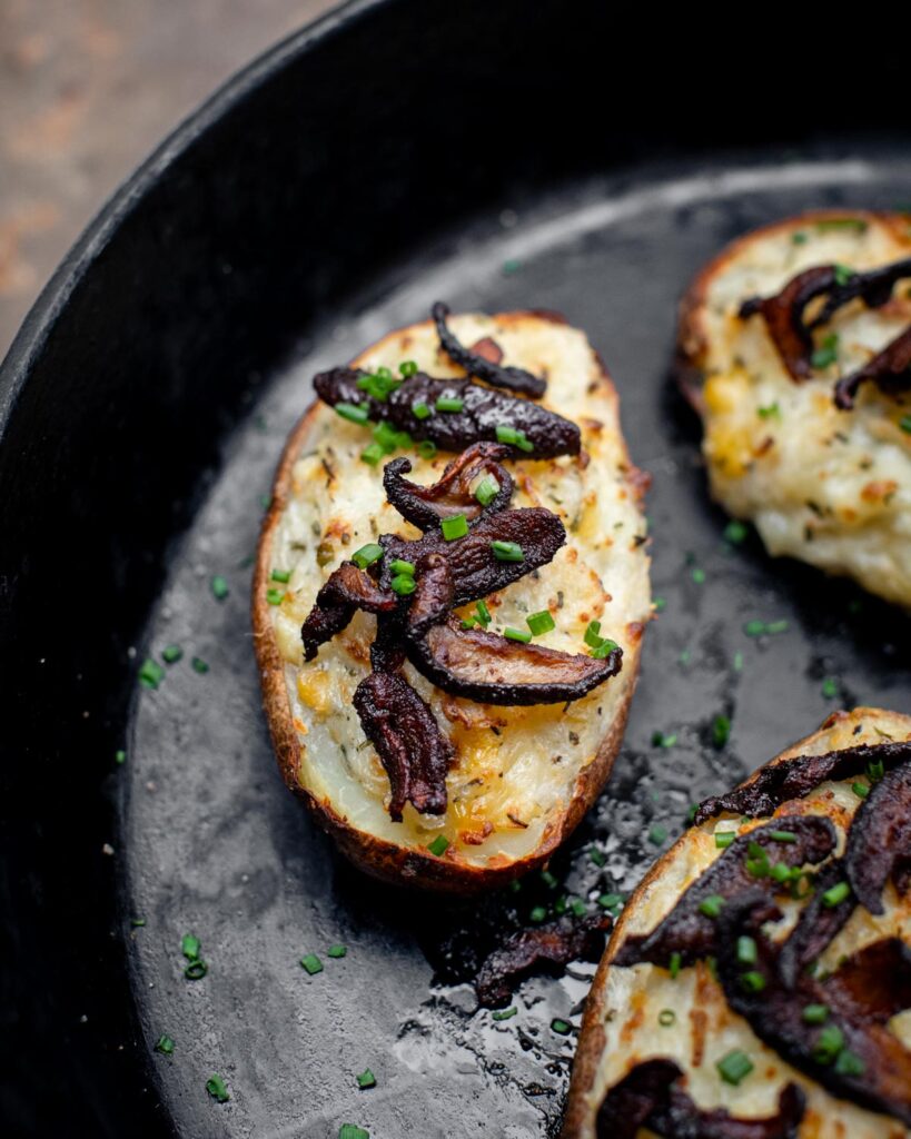 Twice baked potatoes in a skillet with shiitake bacon