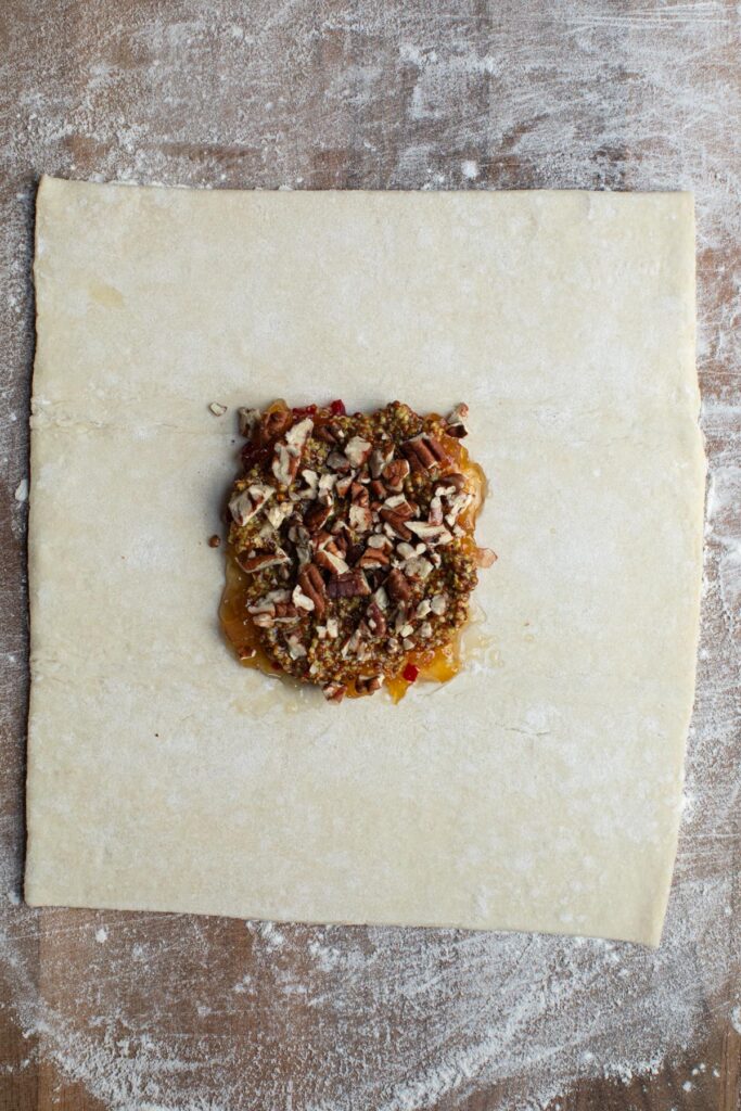 first layer of pepper jelly, mustard, and pecans on dough