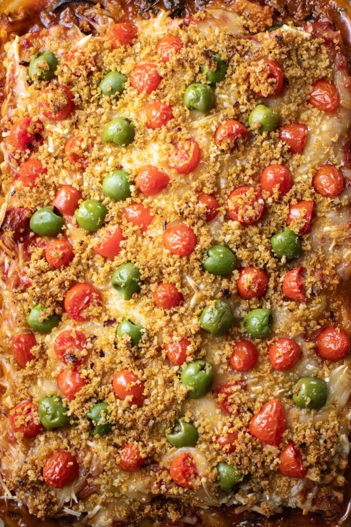 Breadcrumb, tomato, and olive layer in a baking dish for epic lasagna