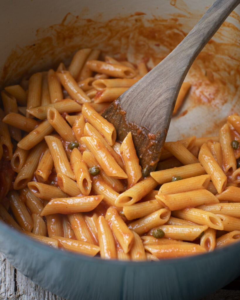 pasta cooked with marinara and capers in a large pot