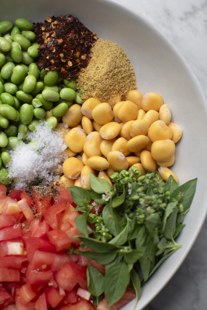 ingredients for salad in a large mixing bowl on a marble table