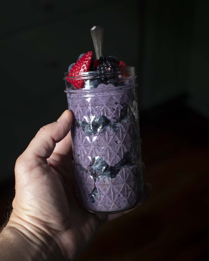 the berry chia pudding served as a layered parfait in a glass jar with berries