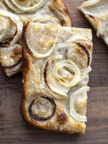 a slice of sourdough focaccia with onion toppings