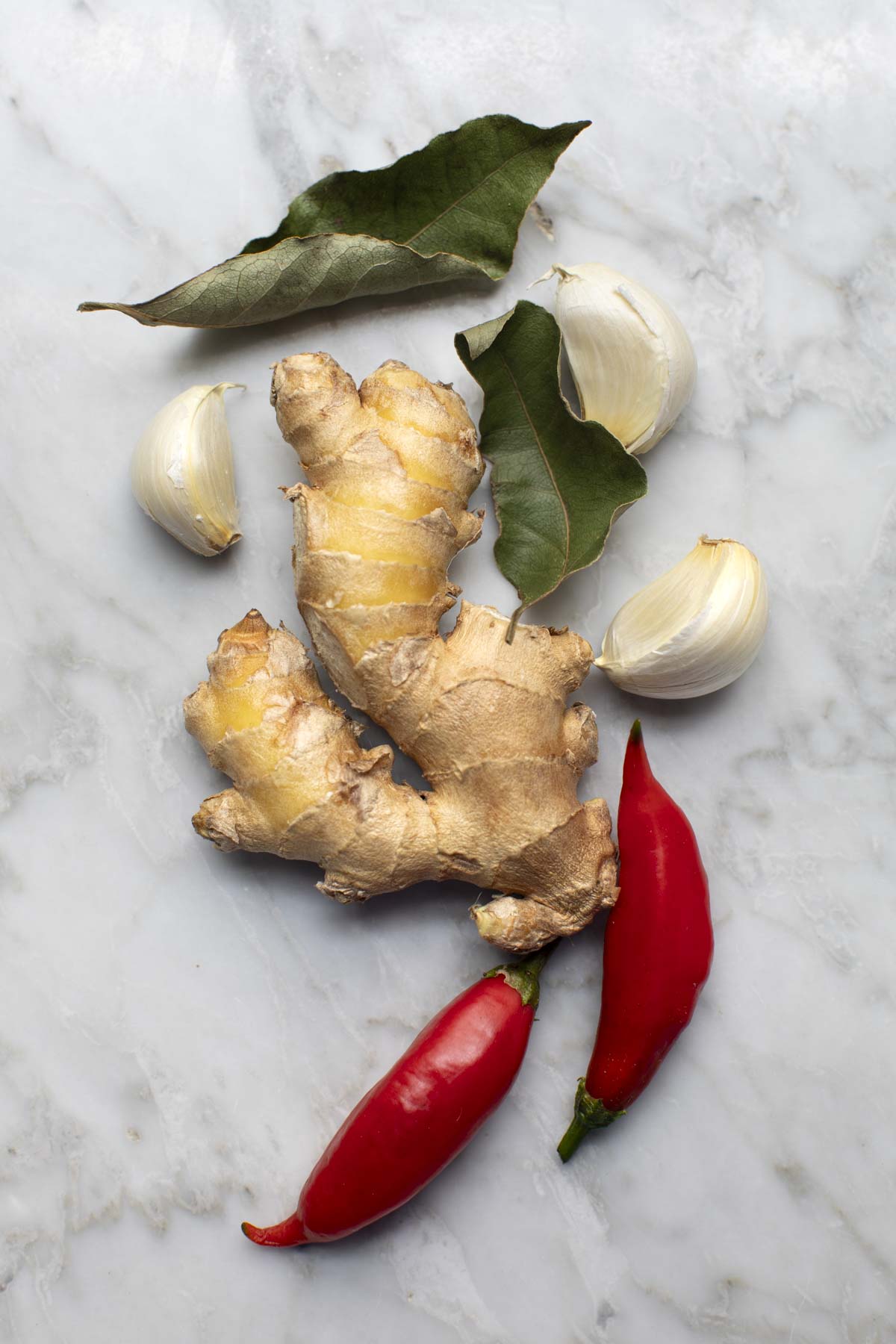 Bay leaves, garlic, ginger, and chilies on a table