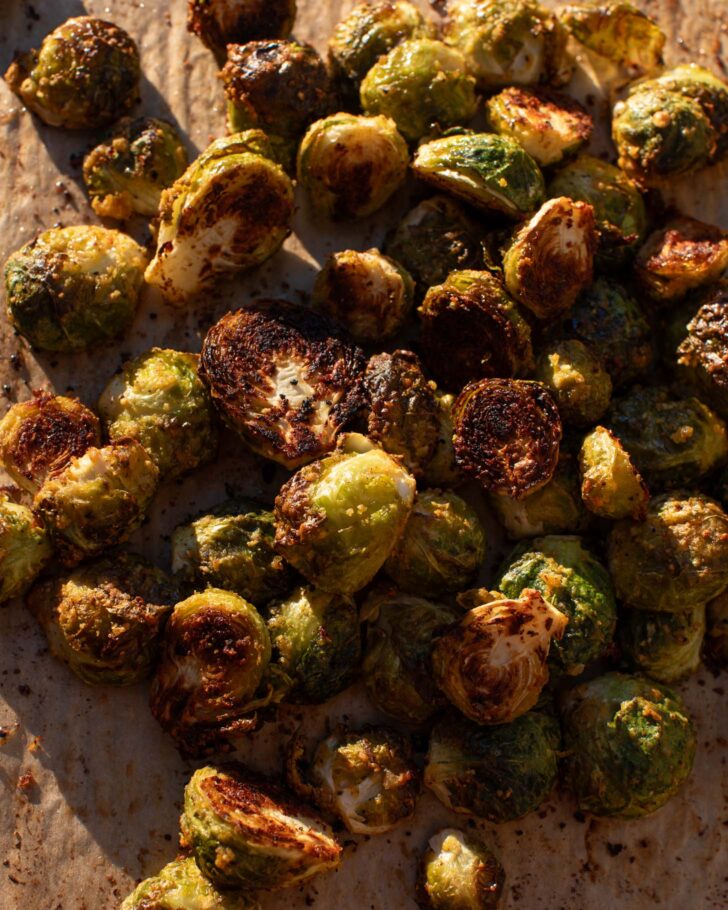 roasted brussels sprouts on a baking sheet in evening light