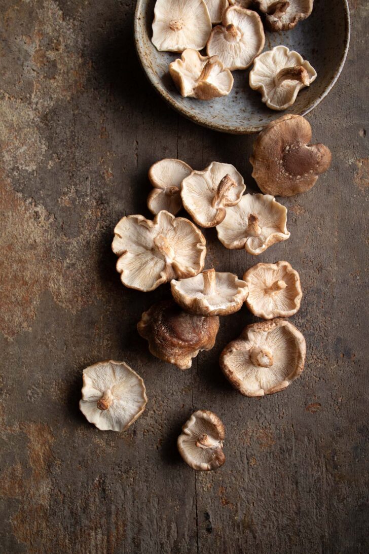 shiitake mushrooms in a bowl and on wood