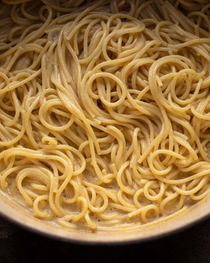 pasta absorbing the sauce in the pot