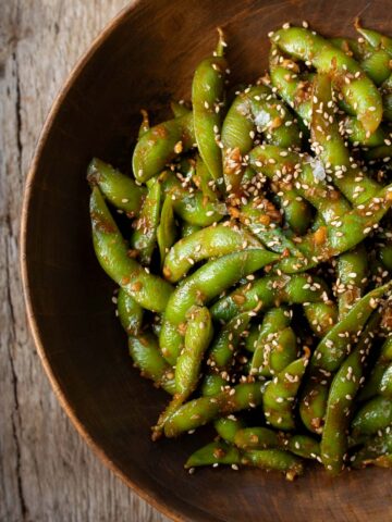 garlic sesame edamame in a wooden bowl
