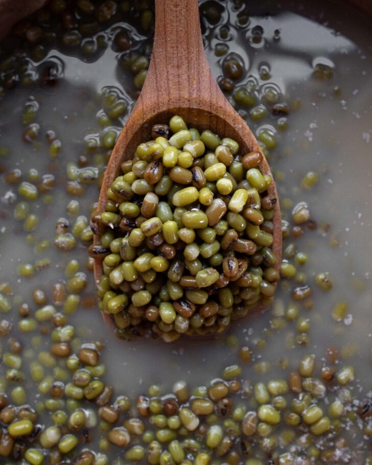 cooked beans on a wooden spoon
