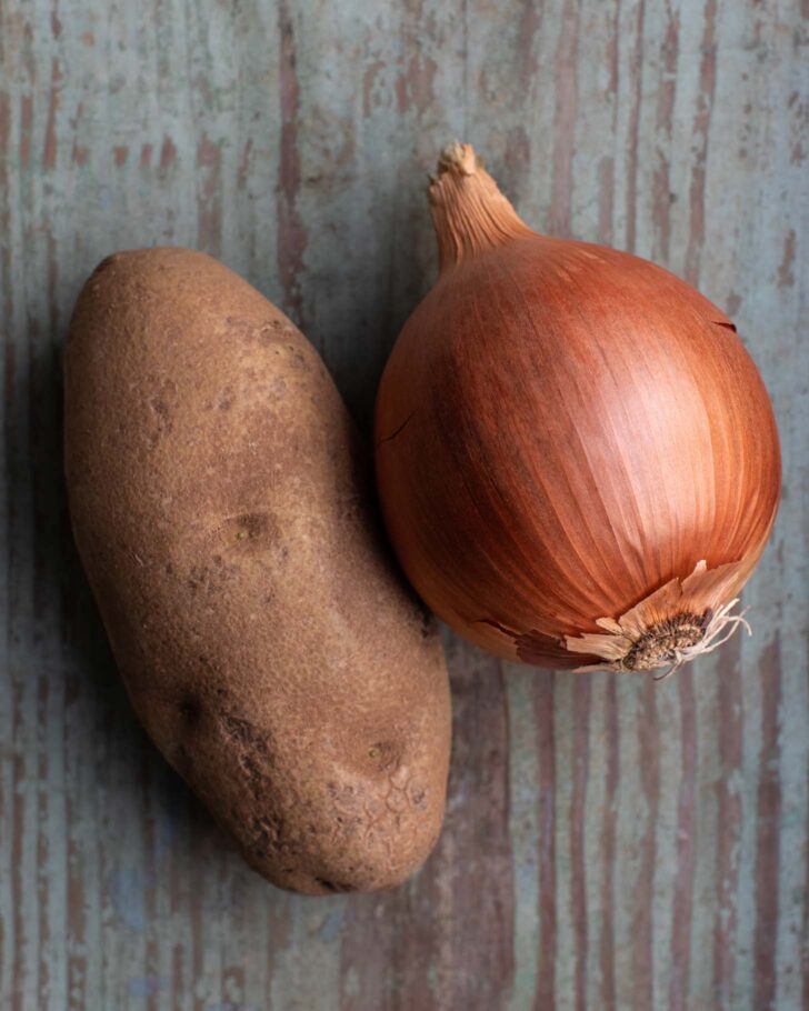 one large potato and onion on wood