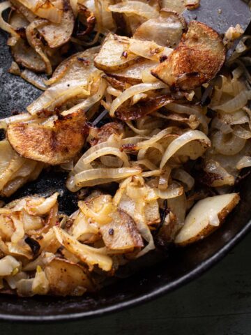 fried onions and potatoes in a skillet