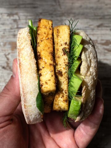 hand holding a vegan breakfast sandwich