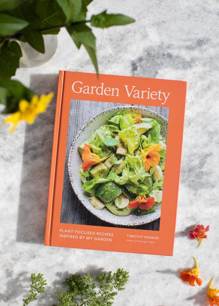 garden variety cookbook on a table with flowers and herbs scattered around